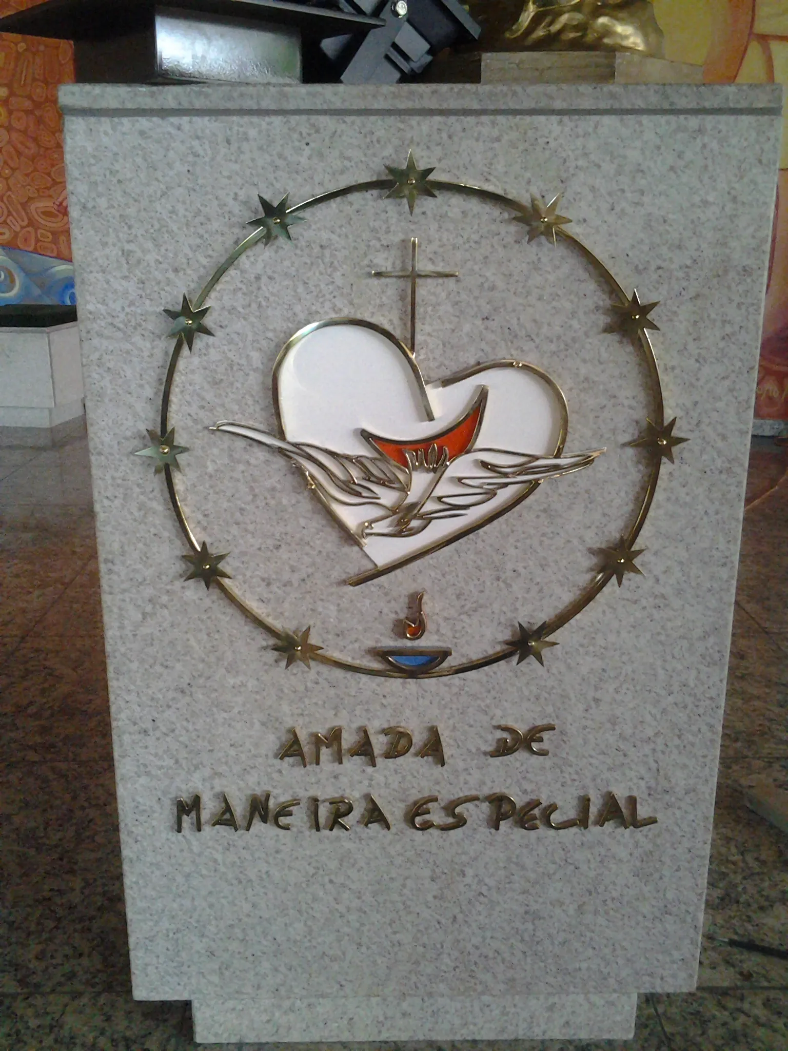 Placa em granito com Sagrado Coração alado e coroa de doze estrelas